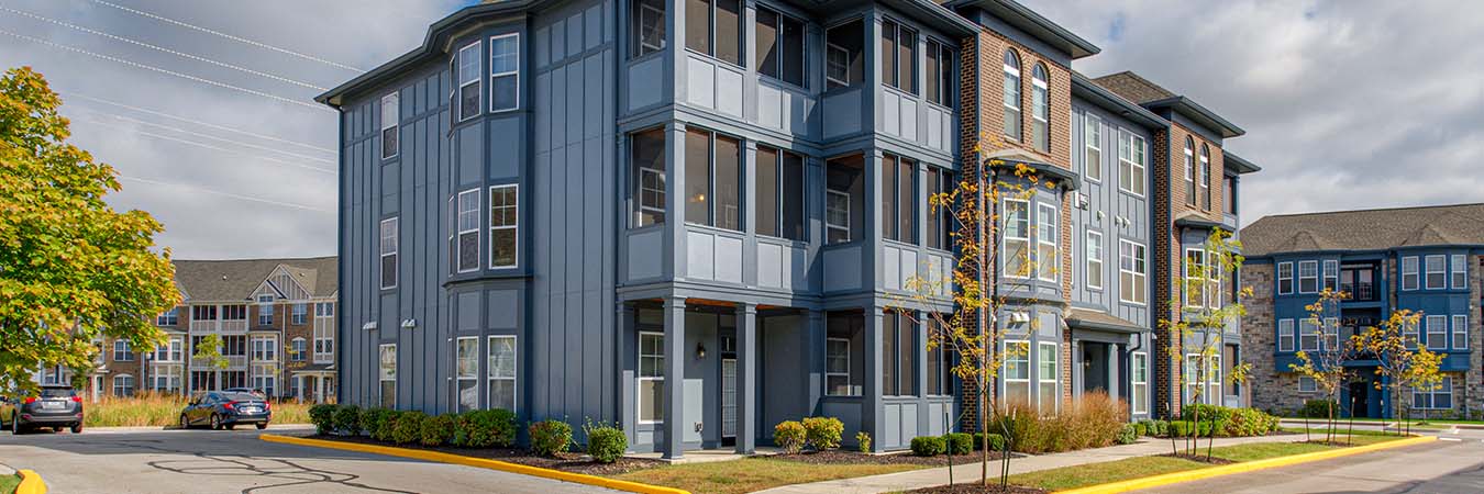 Exterior view of a blue and brown brick apartment building at Ivy Flats Apartments