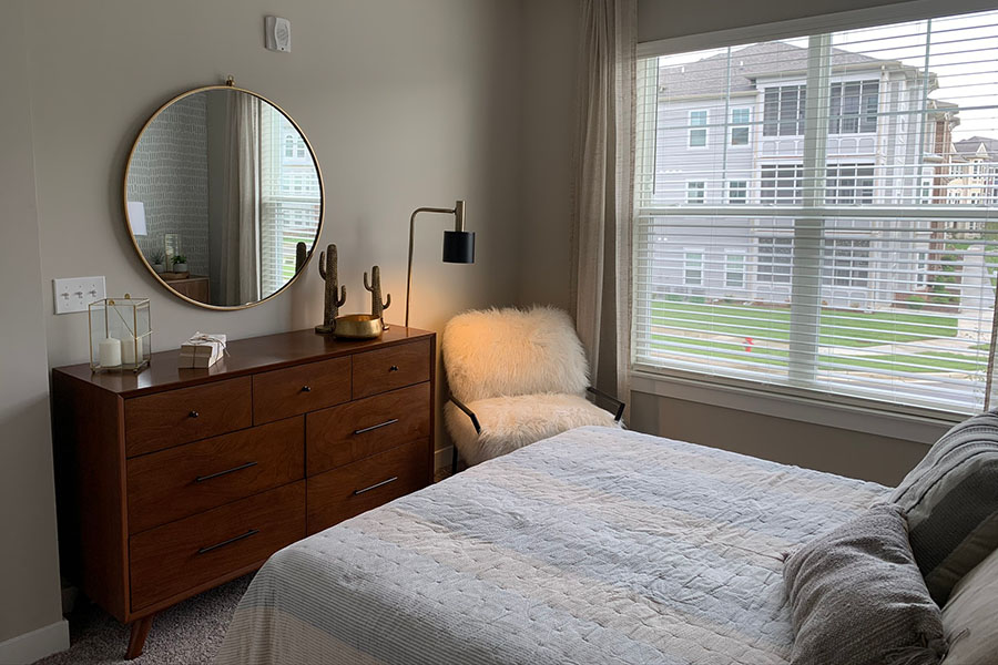 Guest bedroom with dresser and large window.